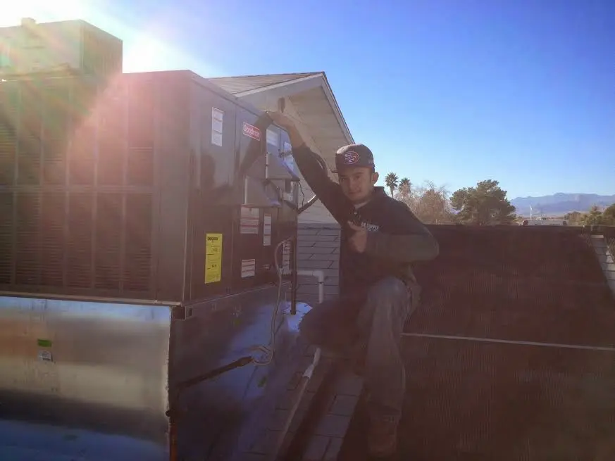 HVAC technician performing AC Tune-Up on a rooftop unit in Graham